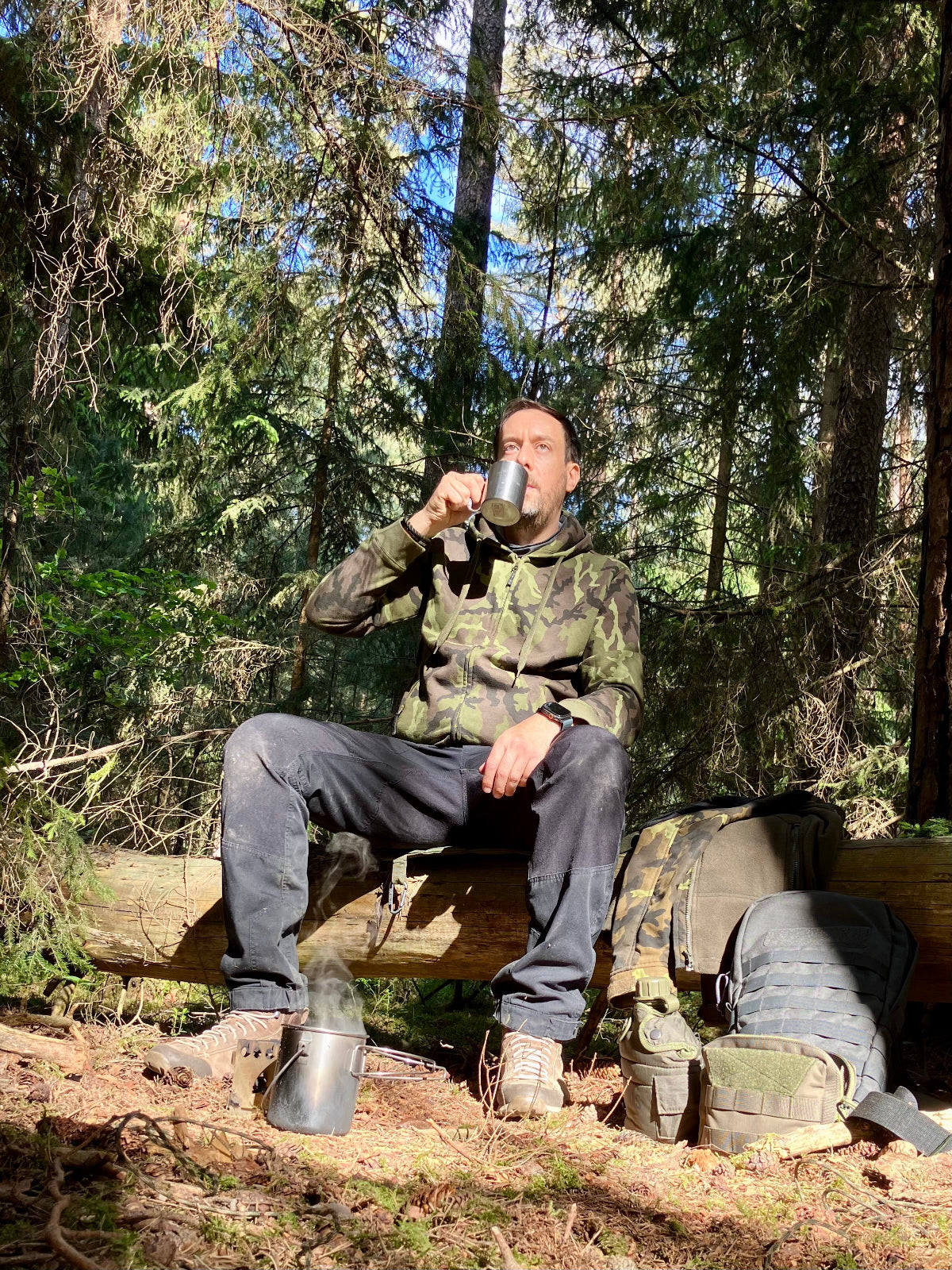 Philipp von Neoapple im Wald mit einer Tasse in der Hand