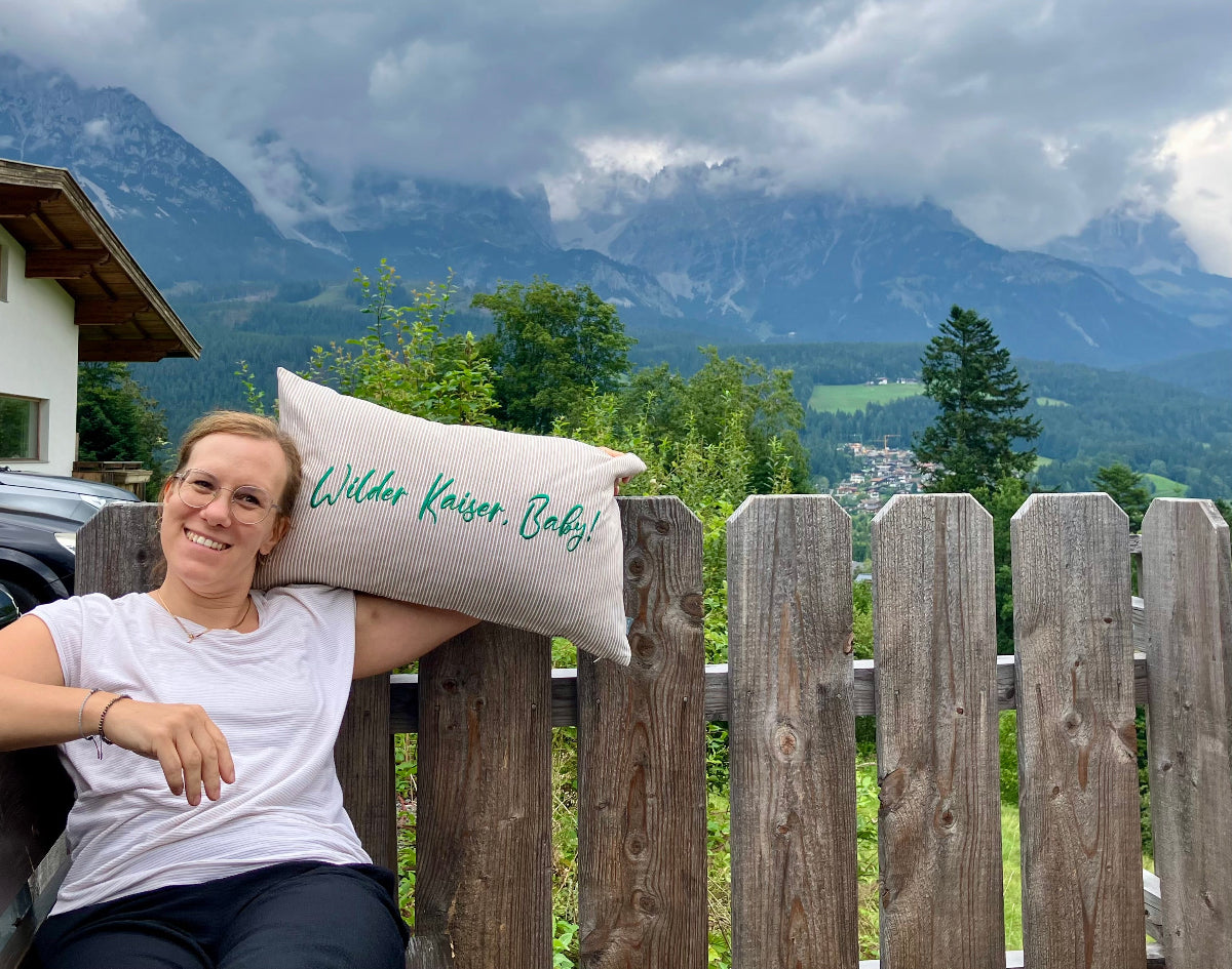 Anna-Lena von Neoapple auf einer Bank vor dem Wilden Kaiser in Österreich 