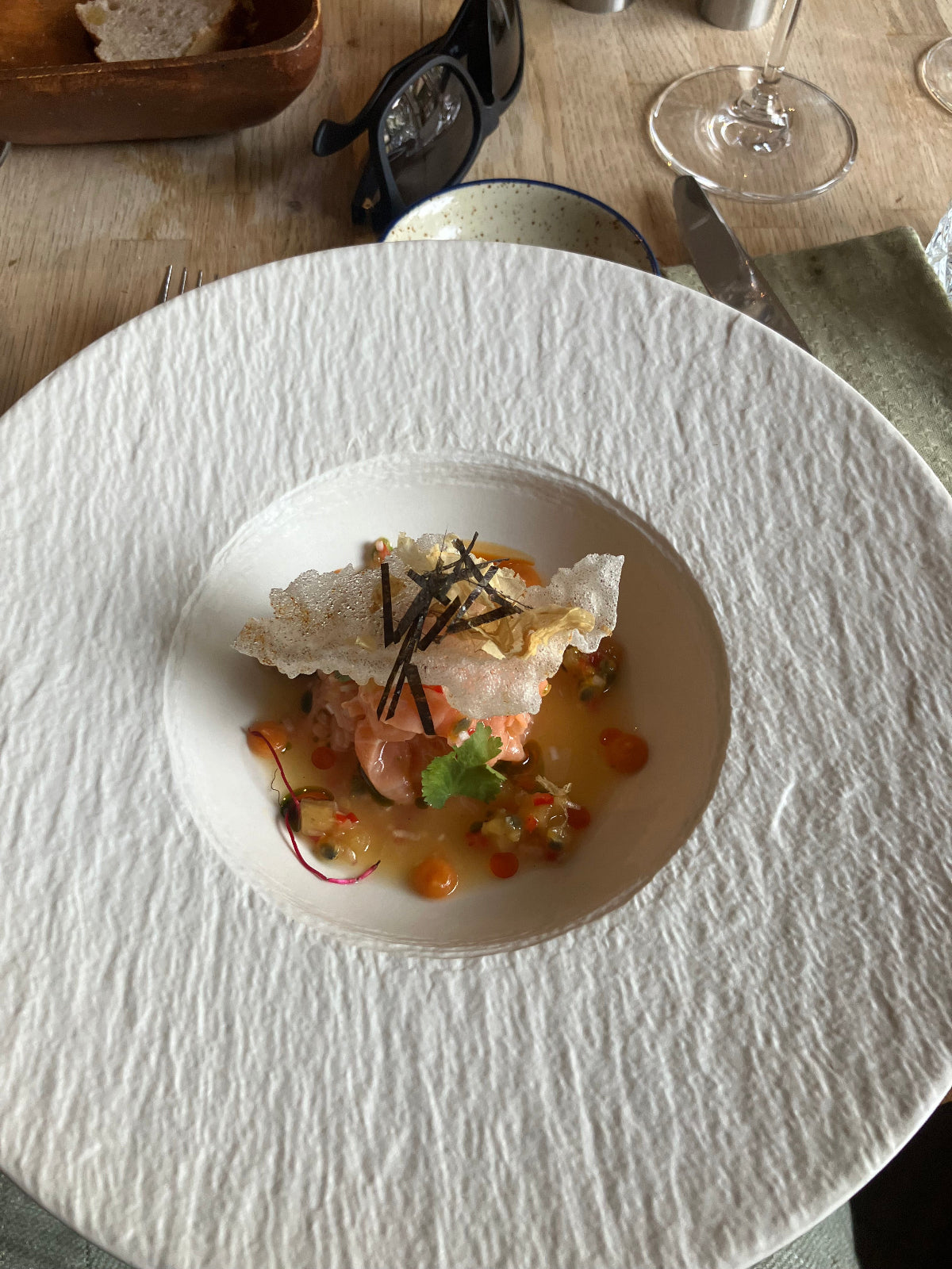 Weißer tiefer Teller mit einem liebevoll angerichteten Gericht im Sterne-Stil